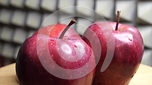 Three wet apples of the red chief variety on a rotating surface. Ripe fruits