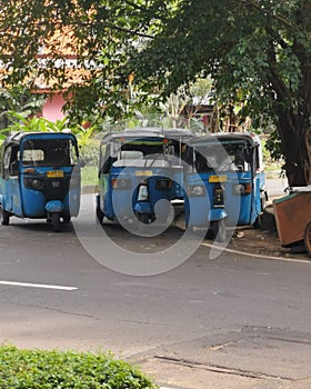 Three-wheeled Bajaj parked on a quiet street