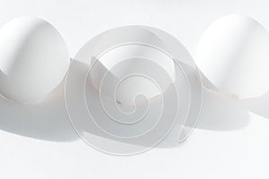 Three white broken eggshells on a white background