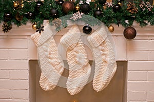 Three white christmas stocking on fireplace background. Xmas holidays