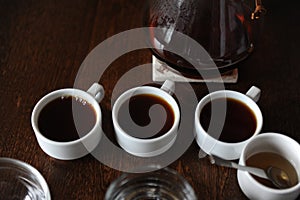 Three white cups with coffee on tasting
