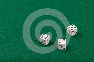 Three White Dice on Green Velvet Casino Table for Gaming and Gambling