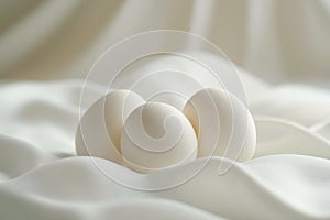 Three white eggs sitting on top of a white cloth