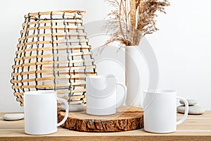 Three white empty mugs mock up on natural wood table.