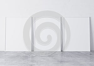 Three white frames,size A3 A4 on White Wall standing on concrete floor. Design Template for Mock Up