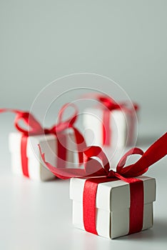 Three white gift boxes with red ribbon in a row