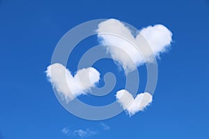 three white heart shaped clouds on blue sky