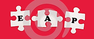 Three white jigsaw puzzles with the text EAP Employee Assistance Program on a bright red background