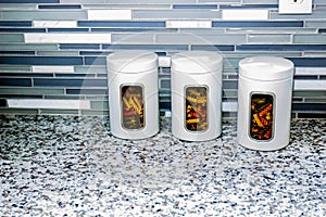 Three White Pasta Canisters On Kitchen Counter