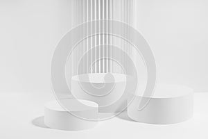 Three white round podiums with striped column as geometric decor, mockup on white background.