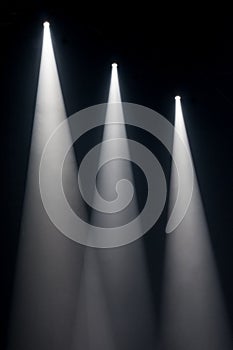 Three white spot lights on stage