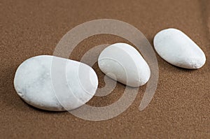 Three White Stones on Brown Sand