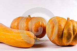 Three whole fresh orange big pumpkin on white background, closeup. Organic agricultural product, ingredients for cooking