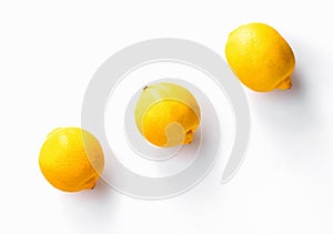 Three whole  lemons diagonally on white background photo