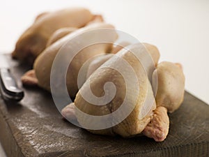 Three Whole Poussins on a Chopping Board photo