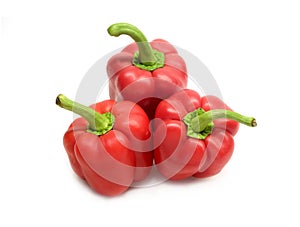 Three whole red ripe bell peppers isolated on white background close up