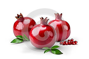 Three whole ripe pomegranates with leaves and seeds on a white background.