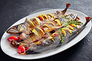 Three whole roasted mackerel on an oval dish