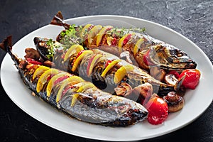 Three whole roasted mackerel on an oval platter