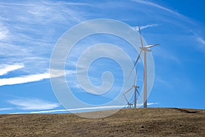 Three wind turbines on top of a hill