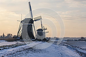 The three windmills in a row during sunrise on a cold winter morning with a snowy landscape at the three windmills in Leidschendam