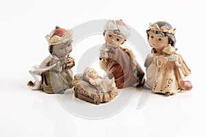 The three wise boys and baby Jesus. Happy Epiphany day concept. Ceramic figures isolated on white background.