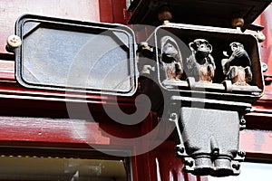 Three wise monkeys small sculptural group placed in antique electric clock fuse box.