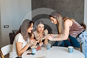 Three woman friends breakfast in the kitchen