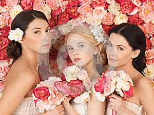 Three women with background full of roses