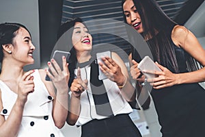 Three women friends chat with mobile phone device.