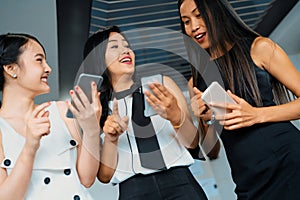 Three women friends chat with mobile phone device. uds