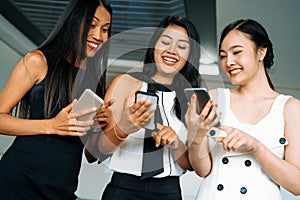 Three women friends chat with mobile phone device. uds