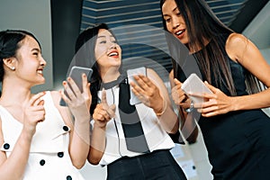 Three women friends chat with mobile phone device. uds