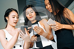 Three women friends chat with mobile phone device. uds