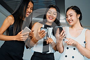 Three women friends chat with mobile phone device. uds