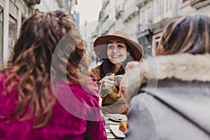 Three women friends having coffee in a terrace in Oporto, Portugal. Having a fun conversation. Lifestyle, tourism and holidays