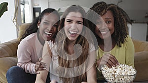 Three women having fun while playing online entertainment video games at home