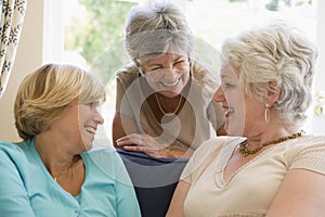 Three women in living room talking and smiling