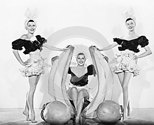 Three women with oversized fruits