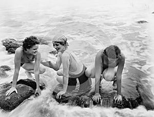 Three women playing in water on the beach