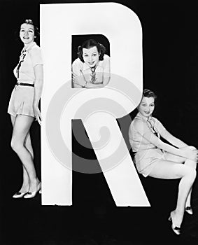 Three women posing with huge letter R