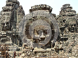 Three women`s faces carved into the stone at Bayon Temple in the Khmer temple complex of Angkor