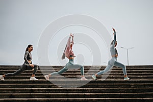 Three women in sportswear doing a workout on urban stairs