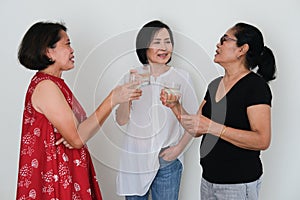 Three women standing and chatting with drinking glass in hands