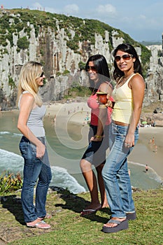 Three women taking chimarrÃ£o on Torres beach