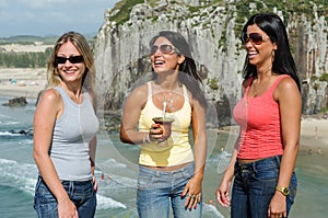 Three women taking chimarrÃ£o on Torres beach