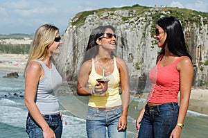 Three women taking chimarrÃ£o on Torres beach