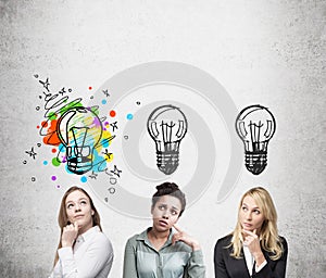 Three women thinking near concrete wall