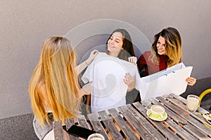 Three women trying new blouse on suiting