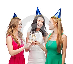 Three women wearing hats with champagne glasses